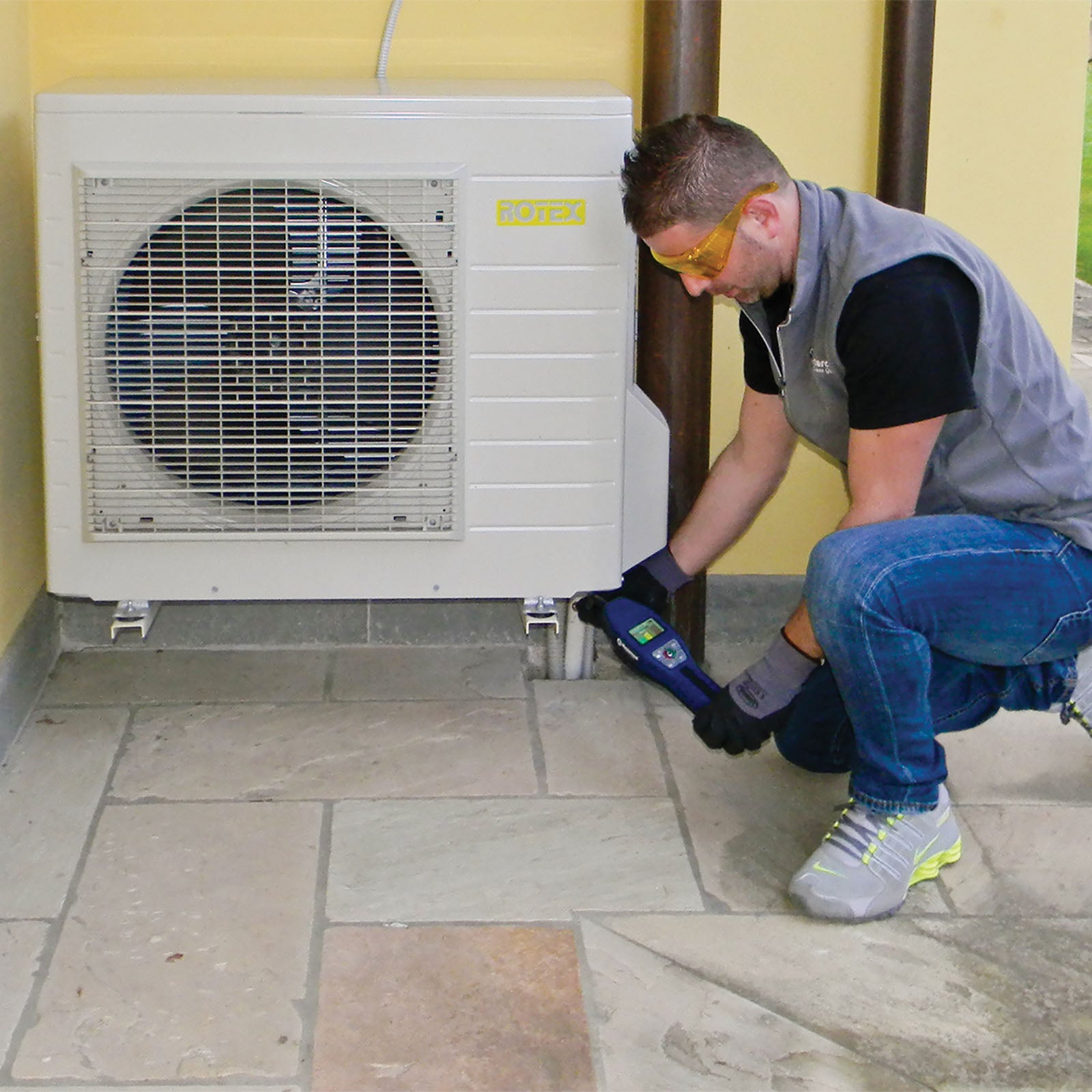 Person working on an air conditioning unit outdoors