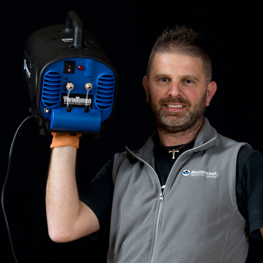 Man holding a blue and black TwinTurbo device against a dark background