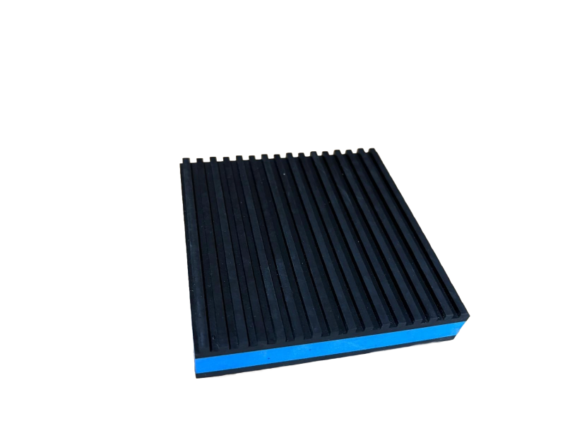 A square foam block with a blue base and a black, ribbed top surface, set against a solid black background. A square foam block with a blue base and a black, ribbed top surface, set against a solid black background.