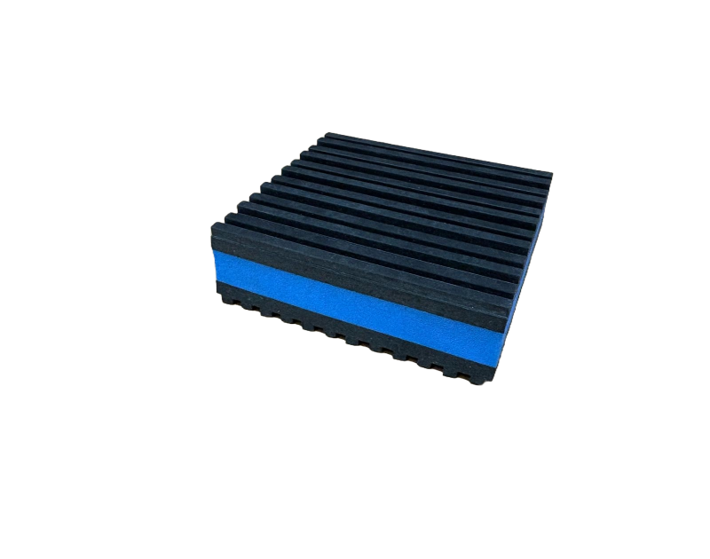 A square foam block with a blue base and a black, ribbed top surface, set against a solid black background. A square foam block with a blue base and a black, ribbed top surface, set against a solid black background.