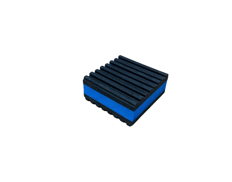 A square foam block with a blue base and a black, ribbed top surface, set against a solid black background.