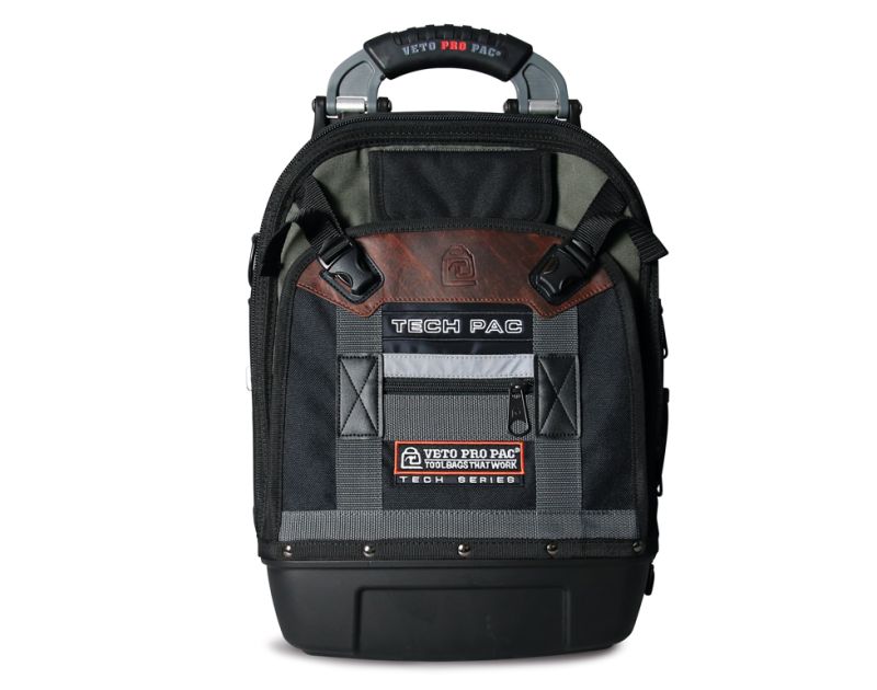 A black Veto Pro Pac Tech Pac tool backpack with a rugged design, featuring a sturdy handle, adjustable straps, and multiple pockets. The bag has a waterproof base, a brown leather accent with the Veto logo, and a label that reads "Veto Pro Pac Toolbags T A black Veto Pro Pac Tech Pac tool backpack with a rugged design, featuring a sturdy handle, adjustable straps, and multiple pockets. The bag has a waterproof base, a brown leather accent with the Veto logo, and a label that reads "Veto Pro Pac Toolbags T