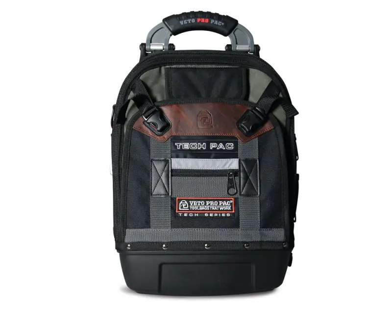 A black Veto Pro Pac Tech Pac tool backpack with a rugged design, featuring a sturdy handle, adjustable straps, and multiple pockets. The bag has a waterproof base, a brown leather accent with the Veto logo, and a label that reads "Veto Pro Pac Toolbags T A black Veto Pro Pac Tech Pac tool backpack with a rugged design, featuring a sturdy handle, adjustable straps, and multiple pockets. The bag has a waterproof base, a brown leather accent with the Veto logo, and a label that reads "Veto Pro Pac Toolbags T