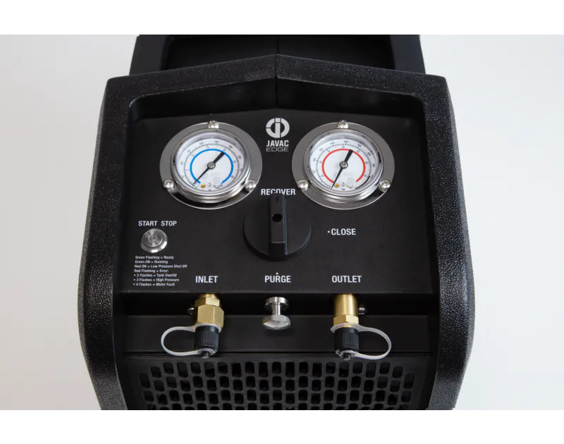 A front view of a black JAVAC Edge Velo-X Recovery Unit, featuring a control panel with two pressure gauges labelled "INLET" on the left and "OUTLET" on the right, with brass fittings and black caps with clear plastic covers. The gauges display pressure i