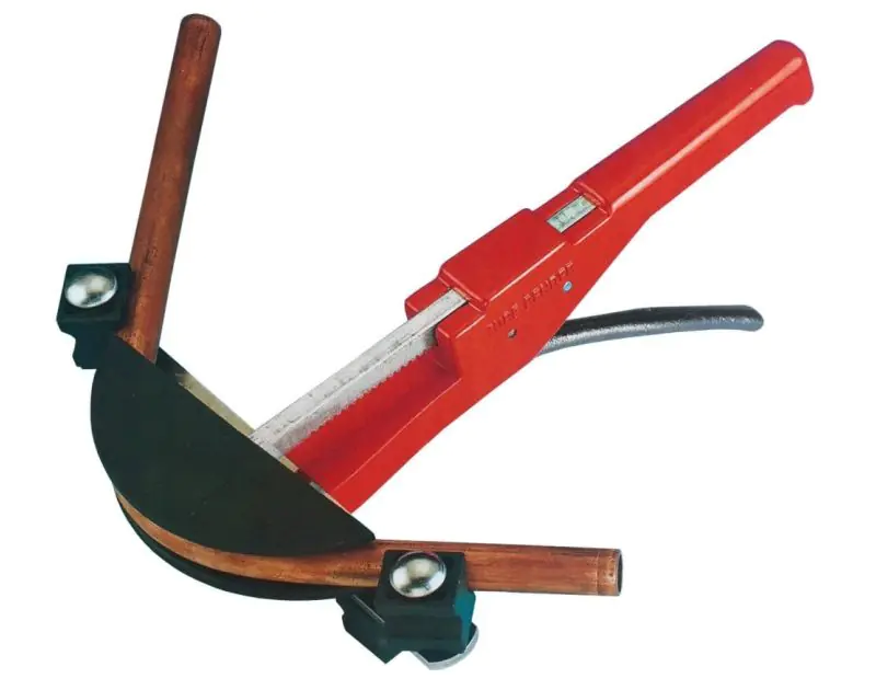 A JAVAC Crossbow Bender with a red handle, bending a soft copper tube. The ratchet hand-held tool features a black bending former and a metallic crossbar, designed for precise bends in air conditioning and refrigeration applications.